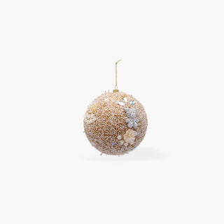 Bola de Natal coberta de lantejoulas e contas em tons de dourado e rosa-pálido, com flores cremes, pedras translúcidas, um pequeno urso prateado e cordão dourado