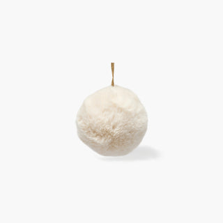 Bola de Natal coberta de pelo macio branco-creme, presa por um cordão em tom de juta, sobre fundo cinzento claro