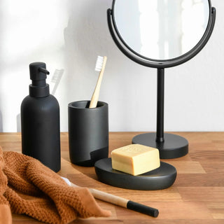 copo porta-escovas em preto, num ambiente de casa de banho com outros acessórios em preto 