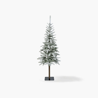 Pinheiro de Natal artificial alto e esguio, com tronco à vista e ramos verdes cobertos de neve, sobre base de metal e fundo branco
